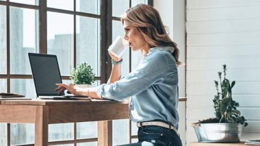 Femme travaillant en home office devant son ordinateur grâce à la solution Xerox® Docushare® Go